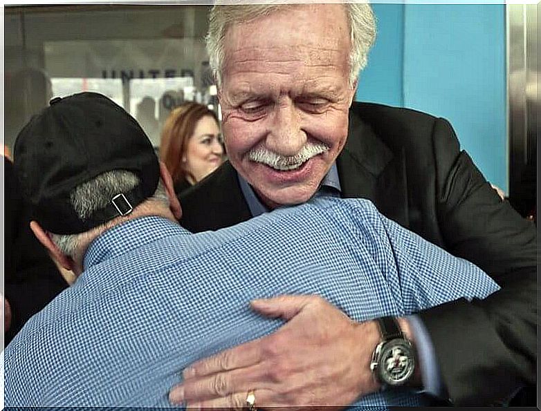 Captain of the miracle on the hudson river hugging passenger