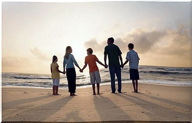 family holding hands on the beach