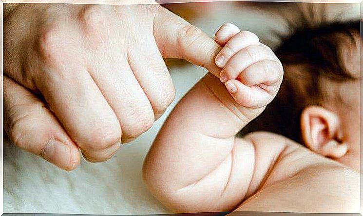 baby holding father's finger