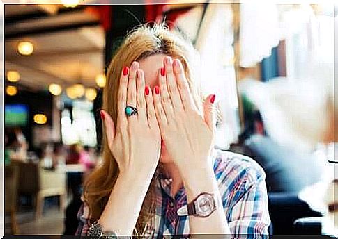 woman covering her face in shame