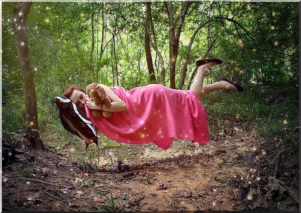 Sleeping woman floating in forest