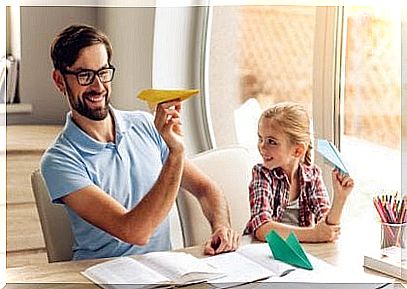 Father and daughter making paper airplane