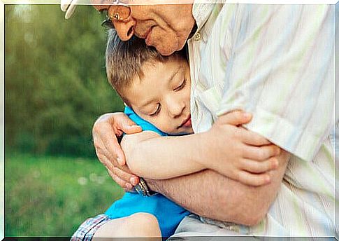 grandfather hugging his grandson