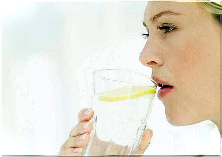 woman drinking water with lemon